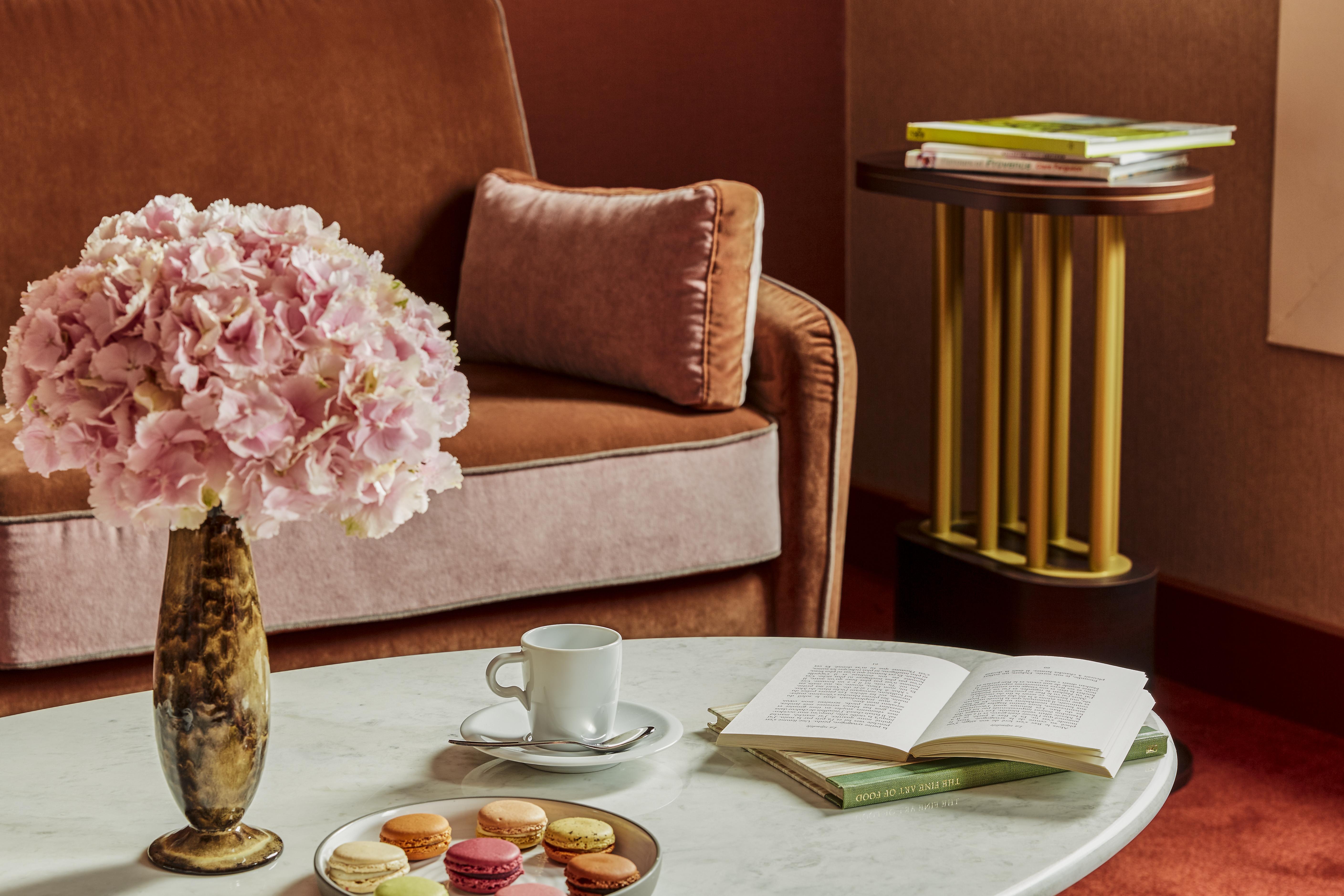 Nest Paris La Defense - Mgallery Puteaux Luaran gambar A table with a coffee cup and saucer, a book, and a vase of flowers