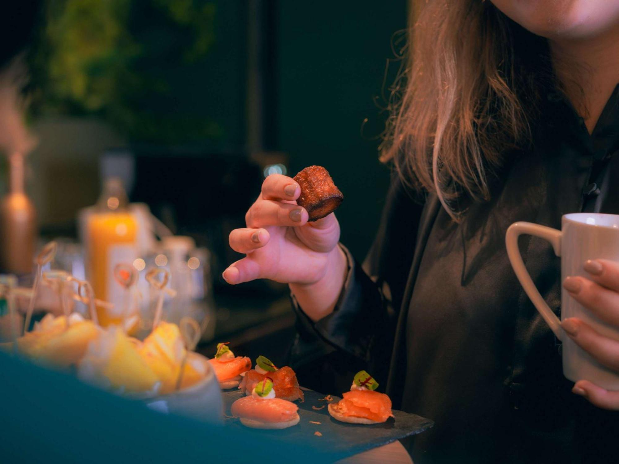 Nest Paris La Defense - Mgallery Puteaux Luaran gambar A woman holding a piece of sushi